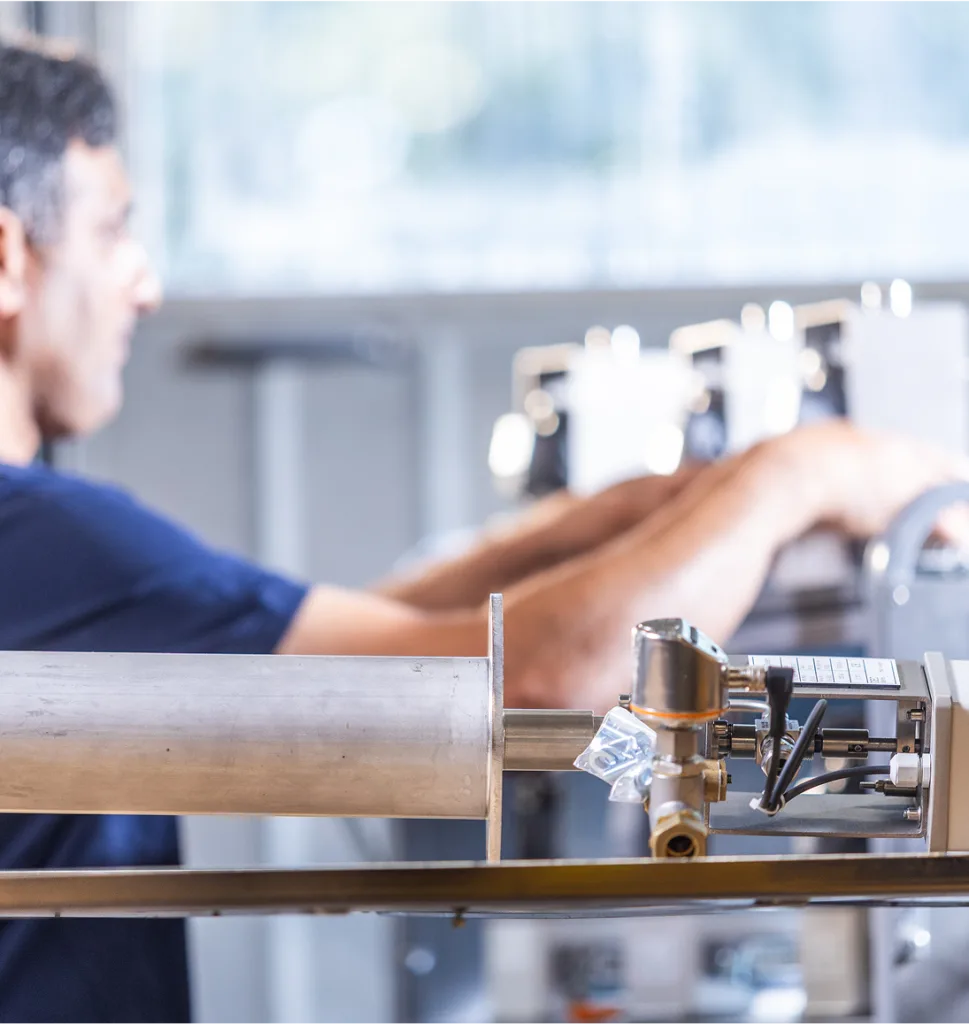 Industrial product in the foreground and warehouse worker int he background interacting with products